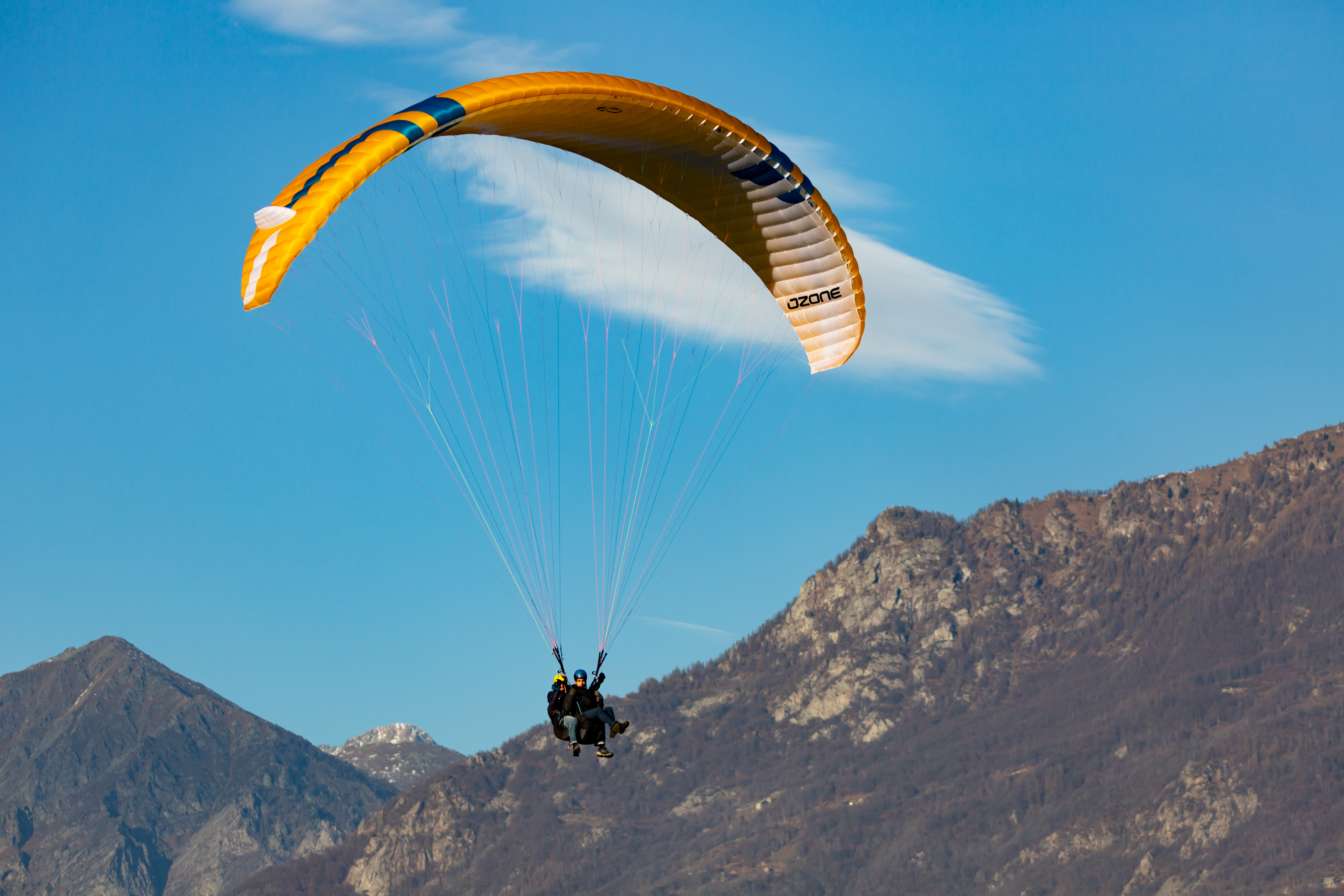 a tandem paraglider flying in the sunset light at Ca' del Monte